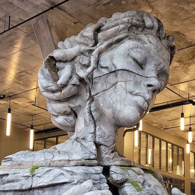 Monumentális nőalak a lakóházak tövében