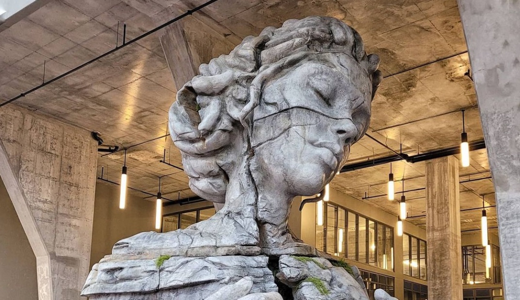 Monumentális nőalak a lakóházak tövében